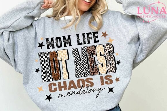 Gray sweatshirt with 'Mom Life Hot Mess Chaos is Mandatory' text and pattern, worn by a person.