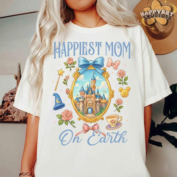Person wearing a white t-shirt with a castle design and 'Happiest Mom On Earth' text.